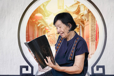 老年妇女在老城读杂图片