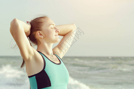 海滩上的女孩闭着眼睛站在沙滩上图片