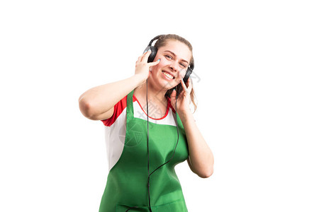 年轻快乐的女超市或零售业雇员在白人背景中孤立地聆听音乐图片