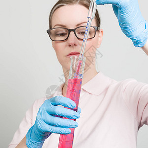女科学家用试管测量实验室中的润滑剂图片
