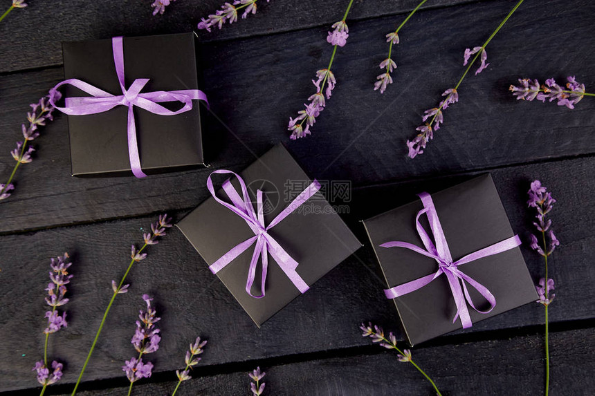 带有紫罗兰色丝带和黑色背景上的薰衣草花束图片