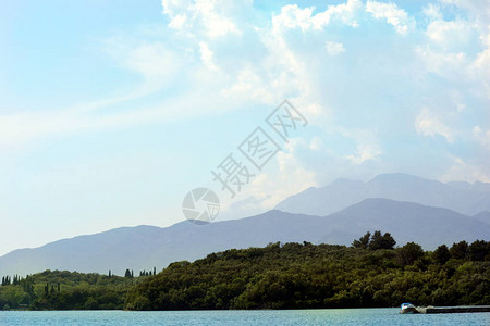 海边的绿色森林背景是山脉和蓝天图片