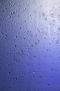 下雨的窗户在淡紫色的背光下滴在玻璃上图片