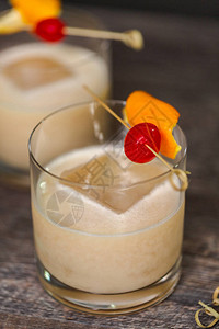 威士忌酸鸡尾酒点缀着橙子和樱桃背景图片