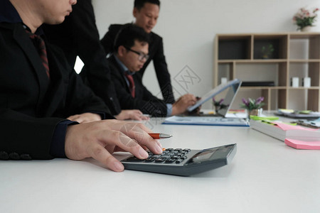 业务检查员分析财务计划报告商人使用计算器来计算预内部审计师在办公室图片