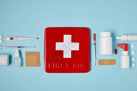 红色急救箱在蓝色表面上面有医疗用品图片