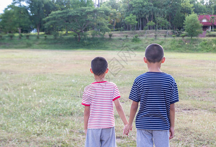 两个前十岁可爱的亚洲男孩站在公共园里夏天有很图片