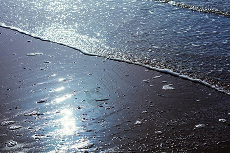 海边有美丽的慢波浪蓝色的海浪和海洋中的泡沫太阳在水中以图片