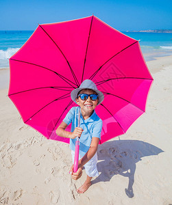戴帽子的可爱男孩在沙滩上图片