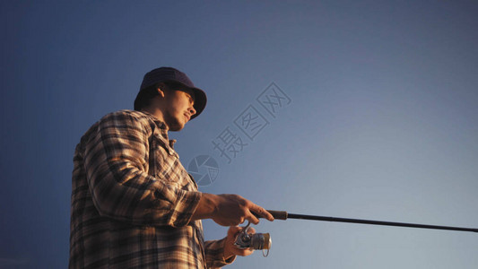 年轻渔民在湖边积极捕鱼图片