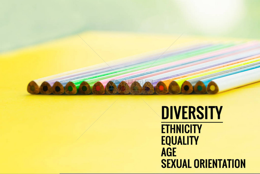 多样概念黄色背景上的一排混合彩色铅笔与文本多样种族平等图片