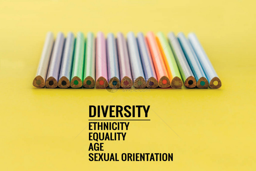 多样概念黄色背景上的一排混合彩色铅笔与文本多样种族平等图片