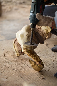 传统手工艺人雕刻木头大象和用电动砂图片