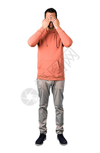 全身穿着粉红色运动衫的男人用手遮住眼睛不想在孤立的白色背景上图片