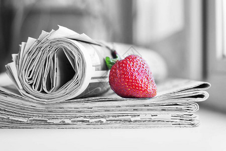 一堆报纸和草莓带有标题和文章以及新鲜水果的每日期刊多图片