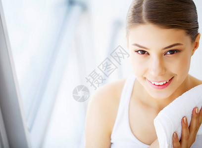 女人用白毛巾清洁面部皮肤图片