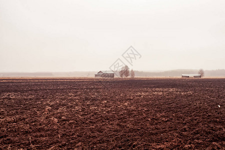 雨水倾泻在芬兰北部泥泞的田野上的小旧谷仓上春图片