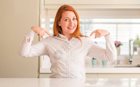 在厨房的红发女人满怀自信面带笑容用手指着自己图片