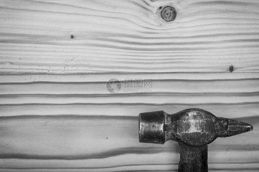 在一张黑色和白色的木桌上的旧锤子图片