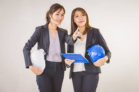 两名商业妇女工业程师头盔手拿图片