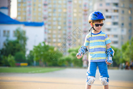 小男孩夏天在公园坐过山车戴头盔的快乐孩子学会滑冰图片