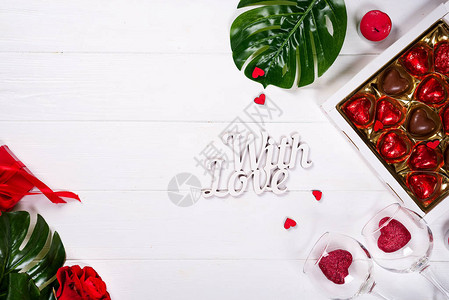 木桌上木质背景上的巧克力红心糖果和玫瑰图片
