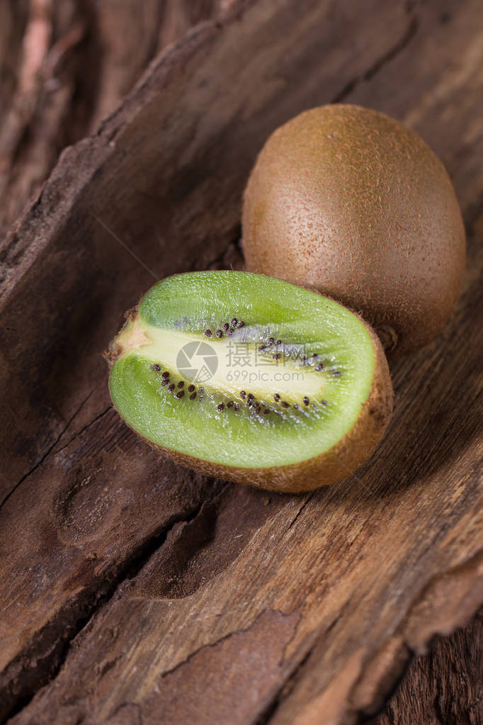 Kiwi水果和半Kiwi水果木制背景图片