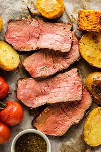 切菜板上的烤牛肉片和烤蔬菜从上面看图片