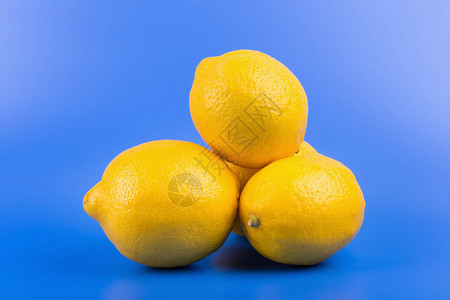明亮的蓝色背景上的新鲜成熟柠檬图片