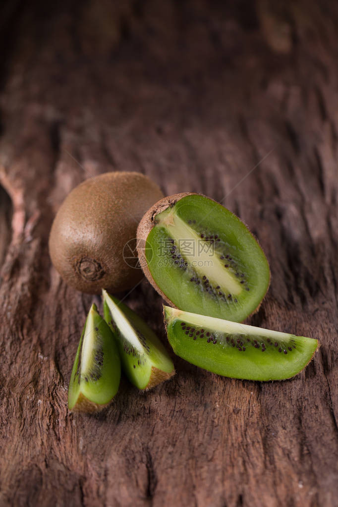 Kiwi水果和半Kiwi水果木制背景图片