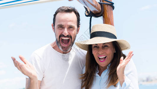 乘帆船旅行的中年夫妇非常高兴和奋图片