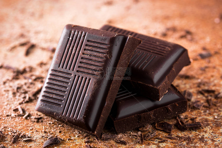 棕色背景上的黑巧克力片图片