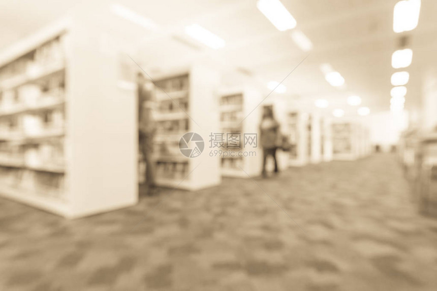 一个女学生在一排书架过道上走着图片