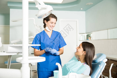 穿着制服的微笑女牙医在牙科诊图片
