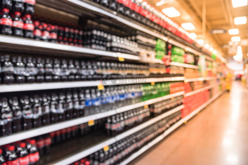 美国商店的软饮料过道图像模糊经济实惠种类繁多的含糖饮料导致美国日益严重的肥胖问题超市货架上展示图片