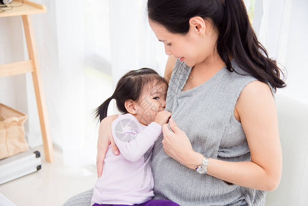 小亚洲女孩在孕妇乳房里喝牛奶时用母乳图片
