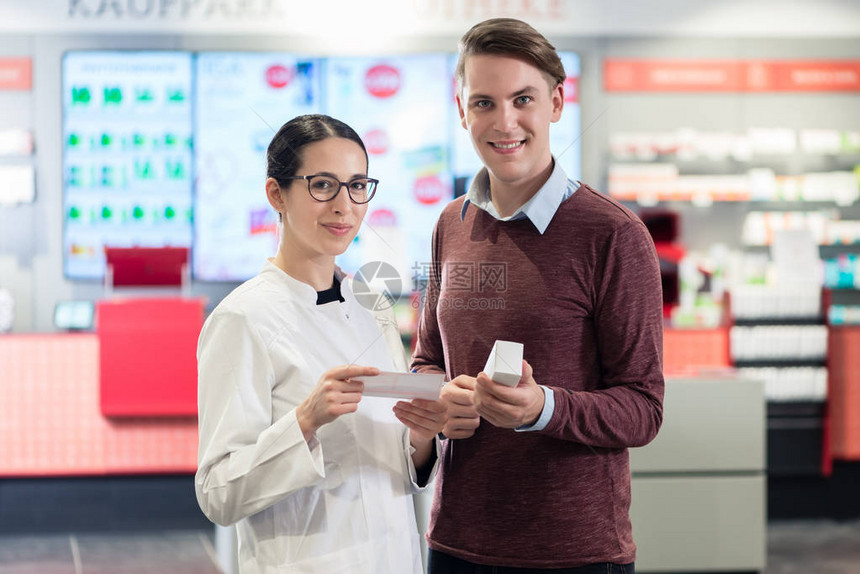 一个英俊年轻男子的肖像在现代药店女药剂师旁边以一个快乐的顾客的身份图片