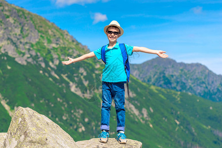 旅行者男孩享受着山的和自由站在图片