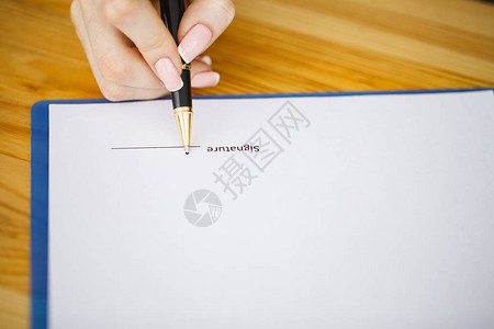 坐在办公桌的女商人签署一份合同只以签图片
