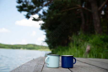 两杯装茶的金属杯子背景为河流图片