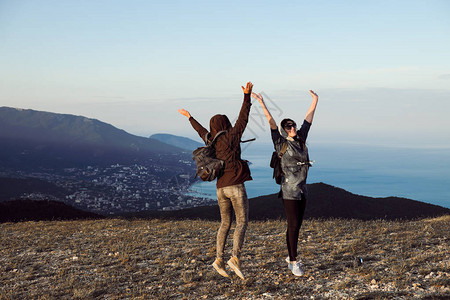 两名女旅行者站在山顶图片