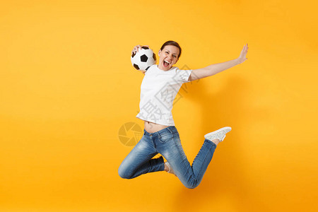 年轻有趣的富有表现力的欧洲女子足球迷在空中跳跃图片
