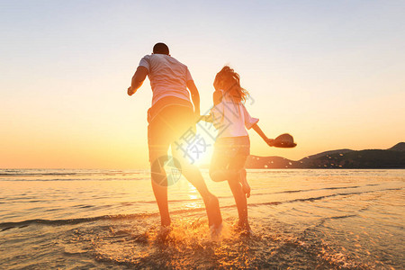 一对夫妇在日落之间的海滩图片