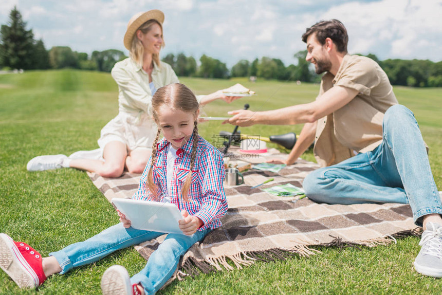 小可爱小孩在野餐时与父母一起休息时图片