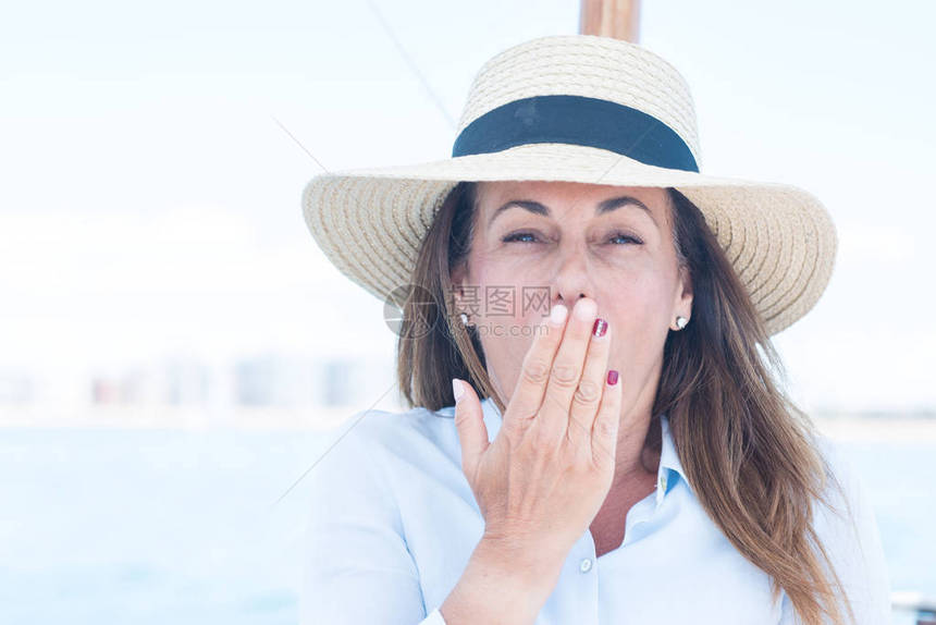 乘帆船旅行的美丽中年妇女用手捂住嘴图片