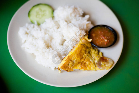 马六甲当地餐厅配黄瓜和桑巴菜的米饭上新制的马来西恩鸡蛋煎饼图片