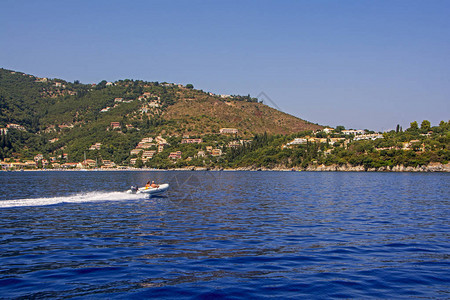 在希腊科孚岛蓝海湾高速航行的一对双船乘坐橡皮图片