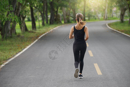 年轻健身女早上在路上奔跑太阳光耀斑选择聚焦点背景图片