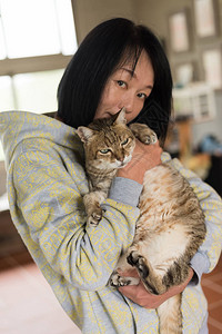 女人在屋里抱着她的老猫图片