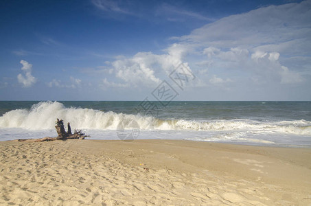 模糊和选择聚焦图像天气和强烈的海浪冲击海岸线阳光明媚的日子和多云的蓝天背景在沙滩背景图片